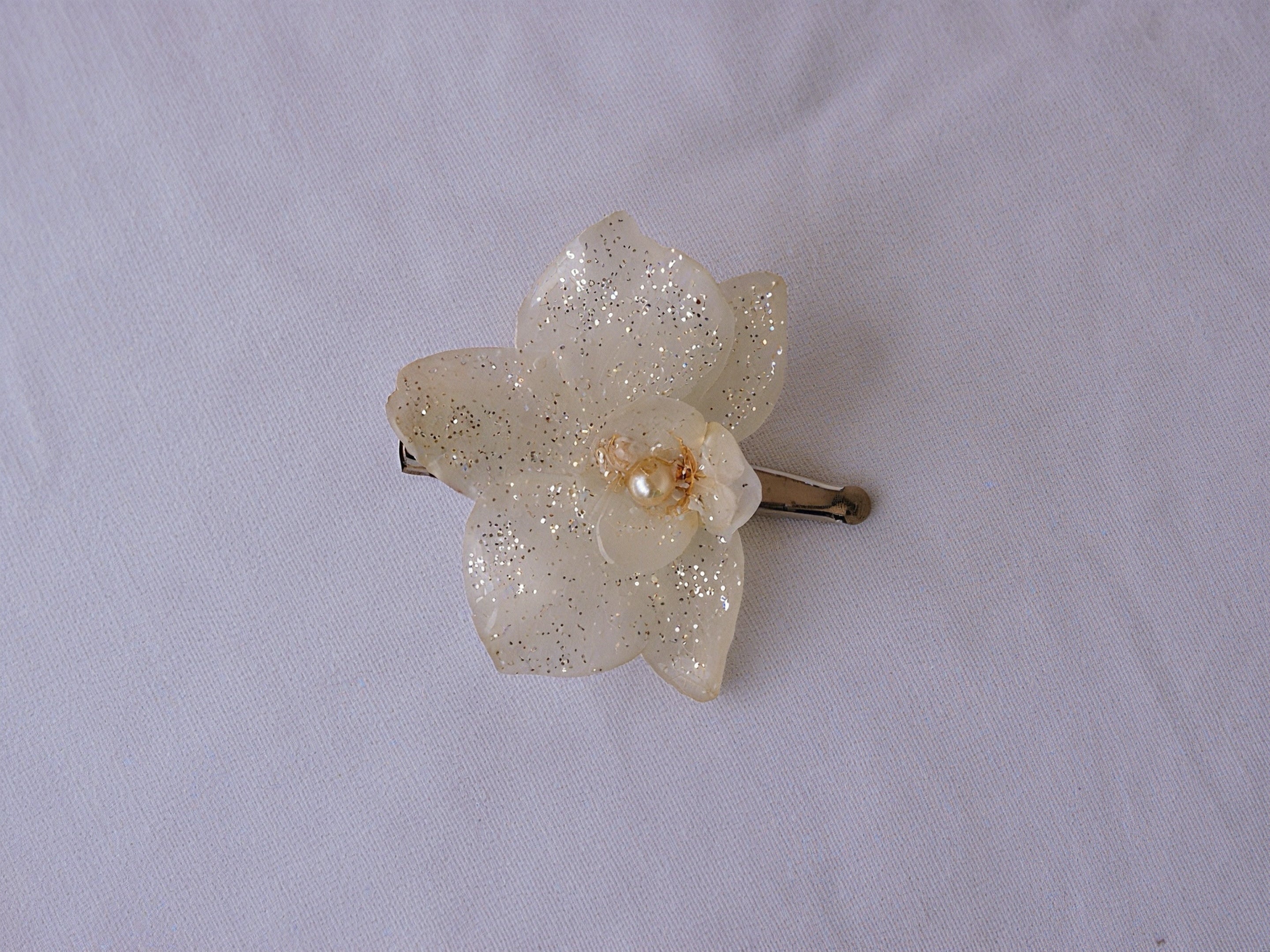 Pinza De Pelo Con Orquídea Natural Resinada, Color Blanco Con Destellos Dorados Y Perla